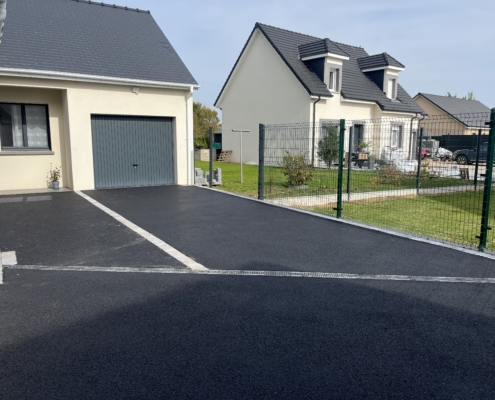 Photo du résultat de la création d'un parking enrobé et pavés à Bourg-Achard en Seine-Maritime. Vue du côté garage