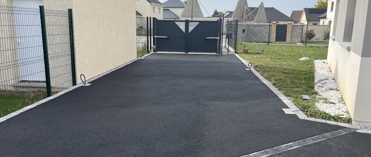 Photo du résultat de la création d'un parking enrobé et pavés à Bourg-Achard en Seine-Maritime. Vue du côté portail